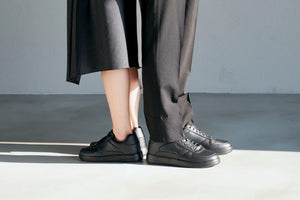 黒いシークレットシューズを履く男性と女性の足元