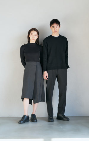 黒いシークレットシューズを履いて壁際に立つ男性と女性のモデル